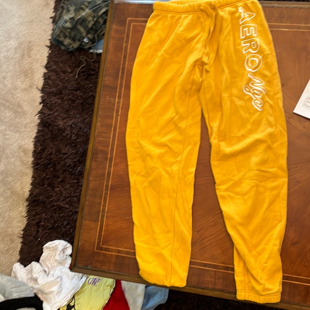 Orange/yellow sweat pants. Aero Nye writing on the side of the pants.